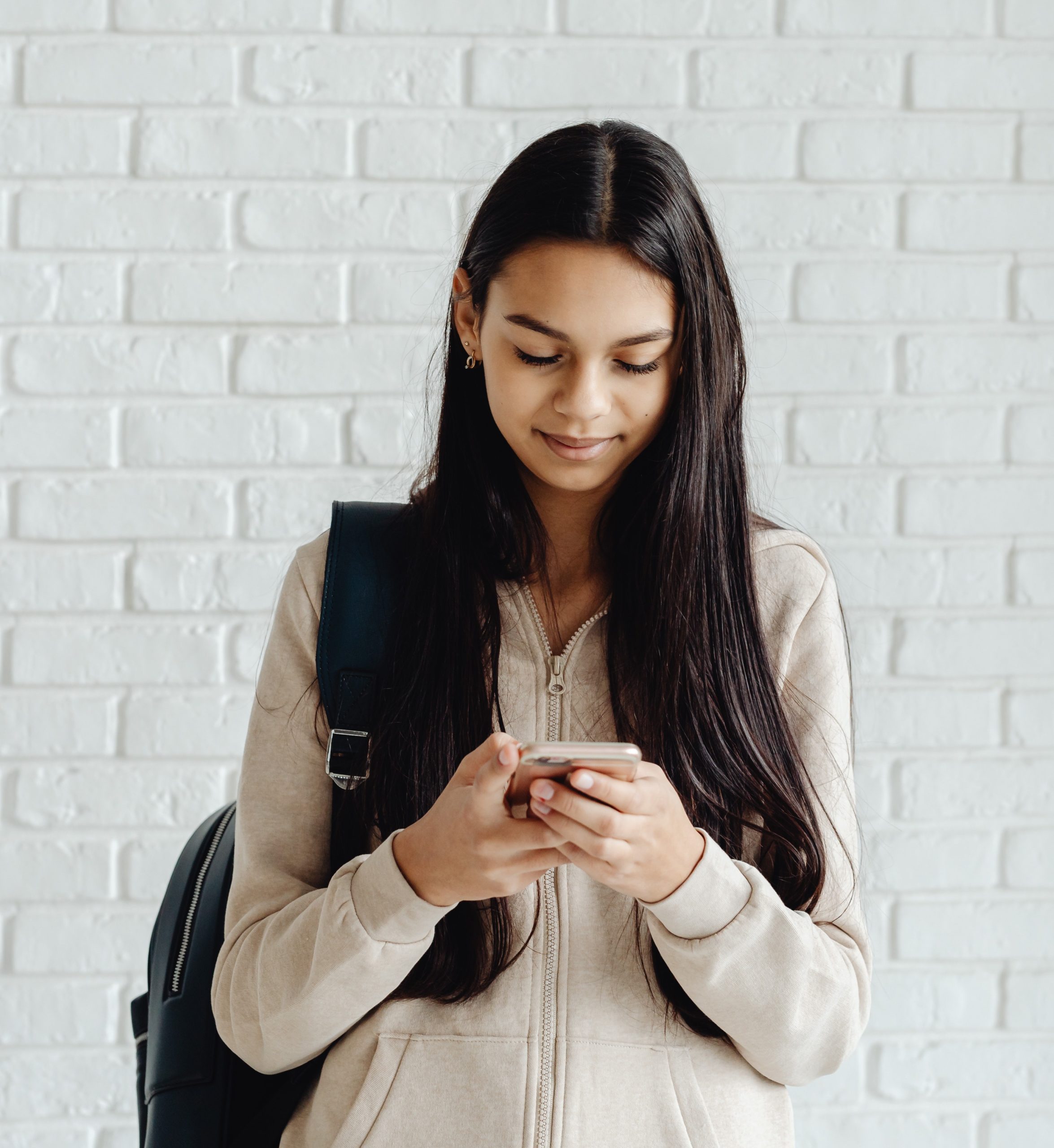 middle school student reading content on cell phone